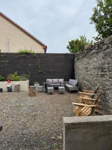 a patio with couches and chairs next to a wall at Church view in Wick