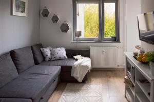 a living room with a couch and a window at Apartamenty Tercet DUO BIS in Ustka