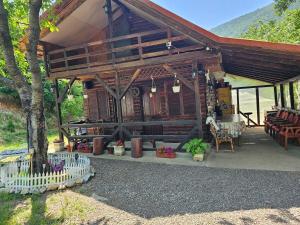a wooden cabin with a fence in front of it at La Cabana in Băile Herculane