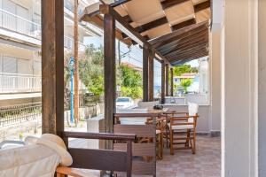 un patio al aire libre con mesas y sillas de madera en Zendaya studios, en Polychrono