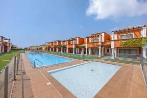 a swimming pool in front of some apartment buildings at Orange Lux Tavira Residence 3I in Luz de Tavira