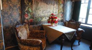 a room with a table and chairs and a vase of flowers at Hotel Villa Antonius in Naantali