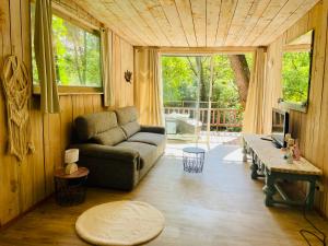 a living room with a couch and a table at Le chalet du Rêveur in La Gaude