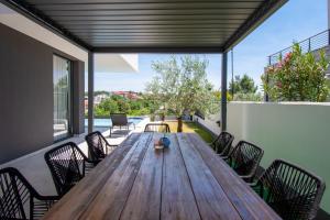 a wooden table and chairs on a patio at Villa Infinity Gem mit beheizbarem Pool in Medulin, Istrien in Medulin