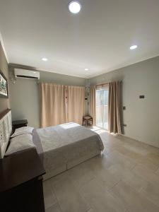 a bedroom with a bed and a large window at Alojamiento la irene in Paso de la Patria