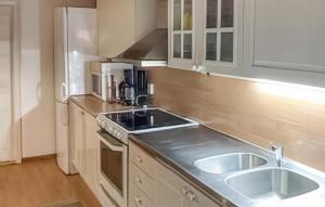 a small kitchen with a sink and a refrigerator at Beautiful Home In Hästveda With Kitchen in Askustorp