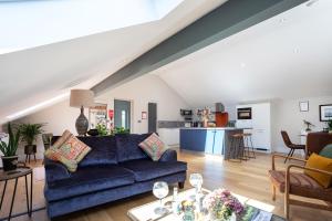 a living room with a blue couch and a kitchen at Bowland Lodges in Lancaster