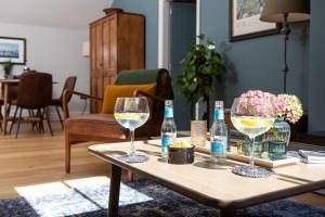 a table with two wine glasses and bottles on it at Bowland Lodges in Lancaster