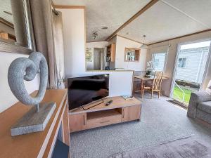 a living room with a flat screen tv and a sculpture at Lovely 6 Berth Caravan For Hire At Manor Park In Hunstanton Norfolk Ref 23044S in Hunstanton