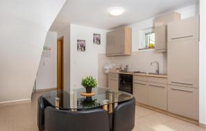 a kitchen with a glass table and black chairs at 2 Bedroom Gorgeous Apartment In Omisalj in Omišalj