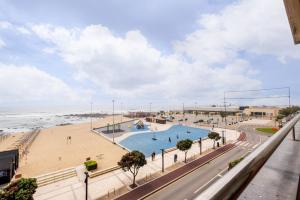 vistas a una playa con piscina y al océano en Beach Front Apartment Av dos Banhos, en Póvoa de Varzim