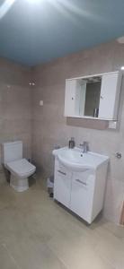 a bathroom with a white sink and a toilet at Villa Mpou in Ávdhira +14 photos