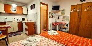 a small room with a bed and a kitchen at Júlia Vendégház Sarród in Sarród