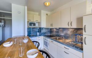 eine Küche mit weißen Schränken und einem Holztisch in der Unterkunft Bel Appartement Proche Mer in Royan