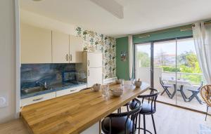 eine Küche mit einem langen Holztisch und Stühlen in der Unterkunft Bel Appartement Proche Mer in Royan
