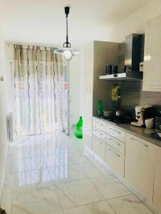 a kitchen with white cabinets and a large window at Casa Vacanze "LE DUE RONDINI" in Venosa