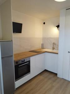 Una cocina con gabinetes blancos y un fregadero. en Studio cosy avec vue exceptionnelle sur l'étang de Thau, en Balaruc-les-Bains 1 foto más