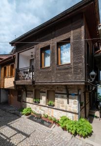 a wooden house with windows and plants on it at Guest House Fotini 2 in Sozopol