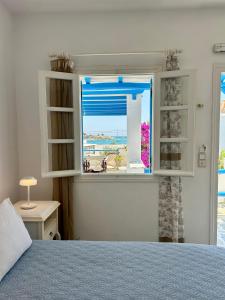1 dormitorio con ventana y vistas a la playa en Sea View Apartments & Studios, en Agia Anna de Naxos