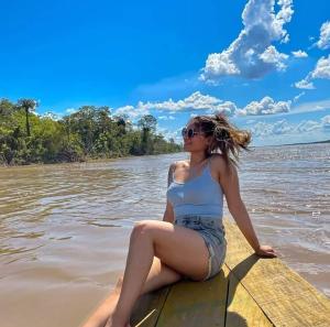 a woman sitting on a paddle board in the water at Ayahuasca y Turismo in Tamshiyacu