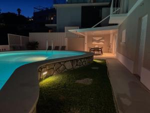 a house with a swimming pool at night at House T3 with Sea View and Private Pool - 5 minutes walk from the beach in Sesimbra