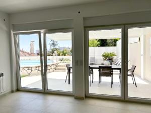 a dining room with sliding glass doors with a table at House T3 with Sea View and Private Pool - 5 minutes walk from the beach in Sesimbra +31 photos