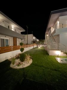 a yard of a house at night with lights at Siesta Thassos - Luxury Apartment in Skala Rachoniou