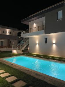 a swimming pool in front of a house at night at Siesta Thassos - Luxury Apartment in Skala Rachoniou