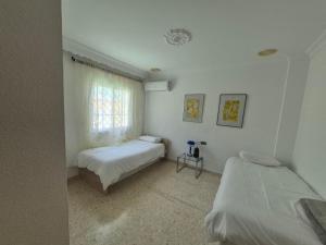 a bedroom with two beds and a window at UF holiday Villa in Málaga +44 photos
