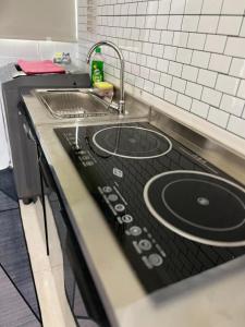 a kitchen counter with a sink and a stove at berTIGA Homestay Bertam in Kepala Batas +14 photos