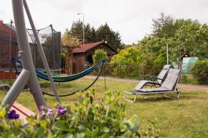 two swings in a yard with flowers in the grass at Apartamenty Tercet, Apartament Kwartet, Apartament DUO in Ustka