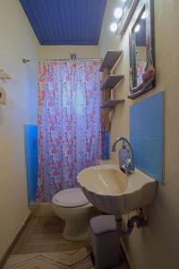 a bathroom with a toilet and a sink and a shower at Villa Helios in Kandia