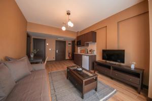 a living room with a couch and a flat screen tv at Servi House - Trabzon in Trabzon