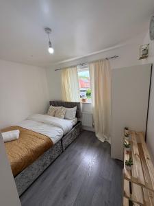 a small bedroom with a bed and a window at The Olive Villa in Manchester