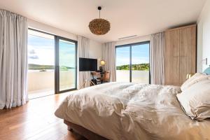 una camera da letto con un letto con vista sull'oceano di La Villa Ghijuvani - Piscine Privée avec Vue Mer a Pianottoli-Caldarello