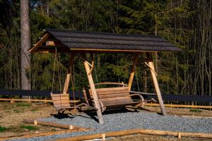 a swing set with a roof on top of it at Domki Tatra Loft in Ząb