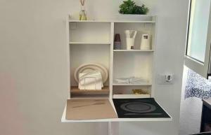 a shelf in a white room with items on it at Rifugio Sul Mare in Vada