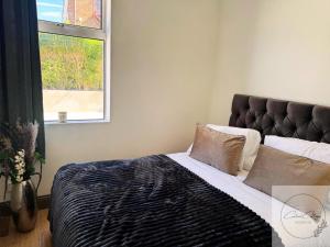 a bedroom with a large bed with a window at Central cottage Newcastle in Newcastle