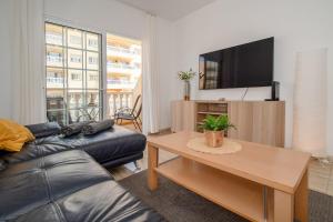 a living room with a couch and a flat screen tv at Apartman Mar Primavera in Arona