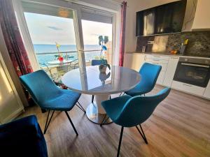 a dining room with a glass table and blue chairs at Apartment Nemo in Jesenice