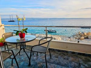a table and chairs on a balcony overlooking the water at Apartment Nemo in Jesenice