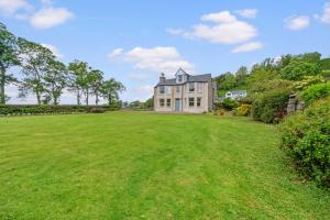 a large grassy yard with a large house at Cuilcheanna House - Onich, Fort William in Onich