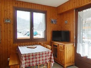 Cette chambre dispose d'une table, d'une télévision et d'une fenêtre. dans l'établissement Studio cabine 4 pers. proche patinoire et pistes, parking, ménage inclus, navette à proximité - FR-1-241-157, au Grand-Bornand