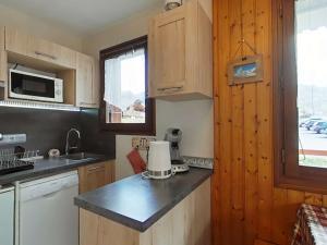 une cuisine avec des armoires en bois et un comptoir dans l'établissement Studio cabine 4 pers. proche patinoire et pistes, parking, ménage inclus, navette à proximité - FR-1-241-157, au Grand-Bornand