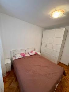 - une chambre avec un grand lit et 2 oreillers roses dans l'établissement Beko Stan 2, à Herceg-Novi