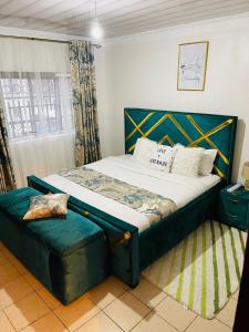 a bedroom with a bed with a blue headboard at Elegant 2 Bedroom Apartment close to Rupa Mall, Noble Hotel,Poa PLace, Mediheal hospital, TopHill Hospital and St Lukes Hospital in Eldoret