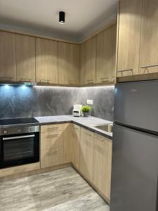 a kitchen with wooden cabinets and a stainless steel refrigerator at Cozy luxury apartment in Perea