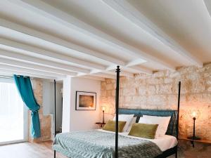 una camera da letto con un letto e un muro di pietra di L'Envolée Sauvage a Cordes-sur-Ciel