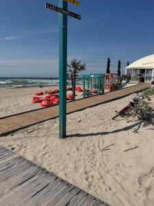 a green street sign on a sandy beach at Seaside apartment x Monciškės in Palanga