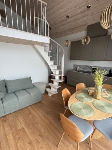 a living room with a table and a staircase at Seaside apartment x Monciškės in Palanga